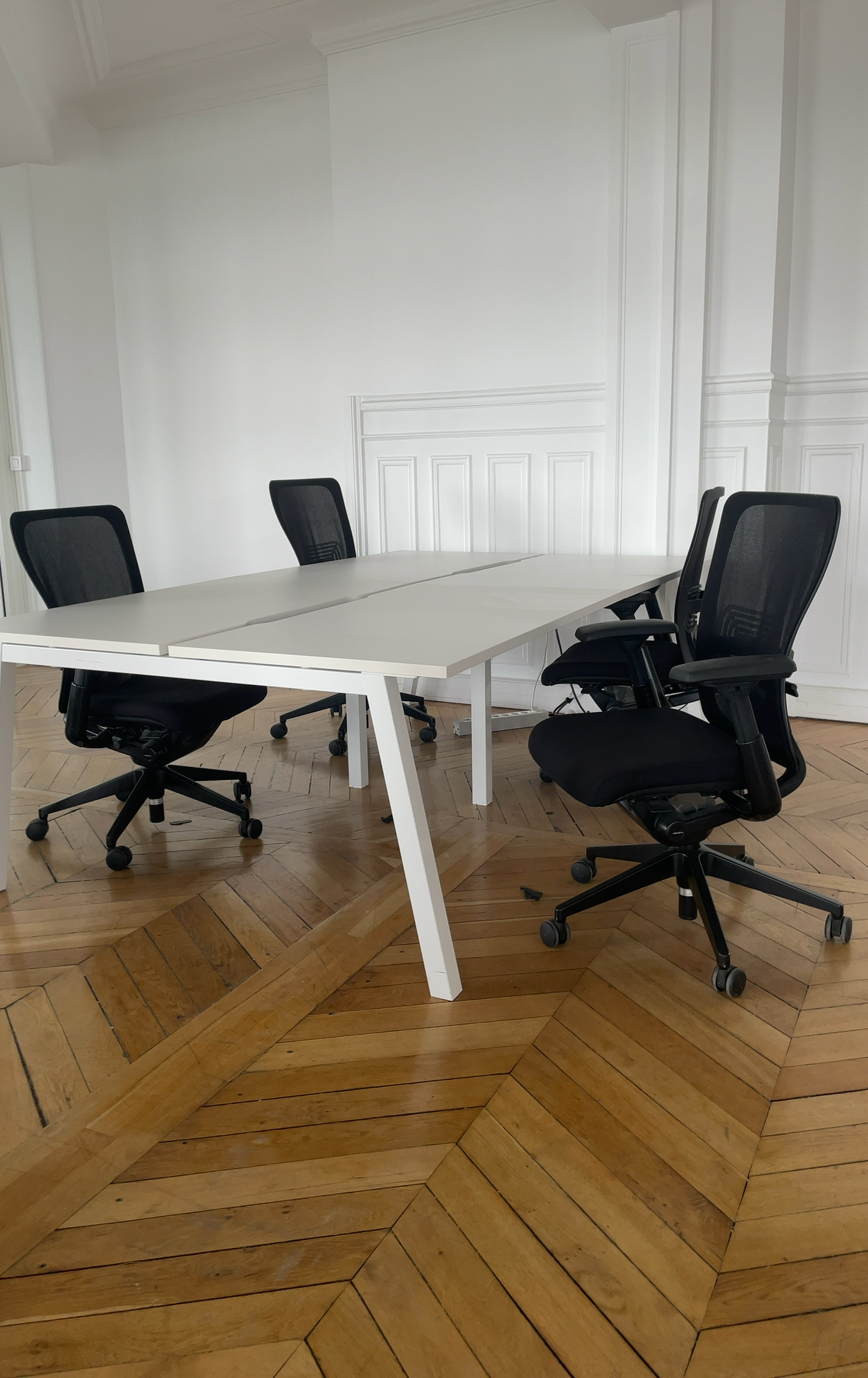 Agencement open space durable avec bureaux blancs et sièges reconditionnés.
