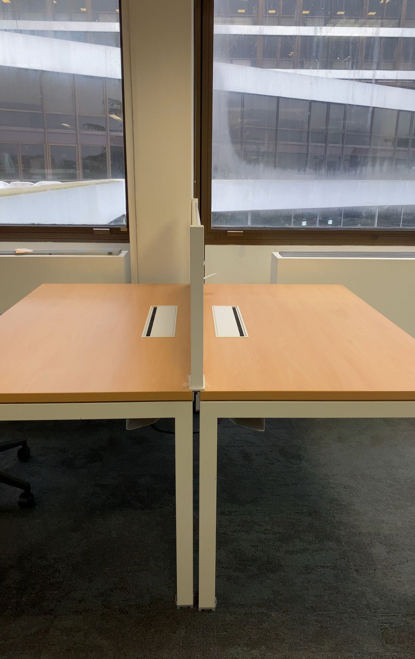 Poste de travail partagé avec bureau bench reconditionné et cloison centrale.