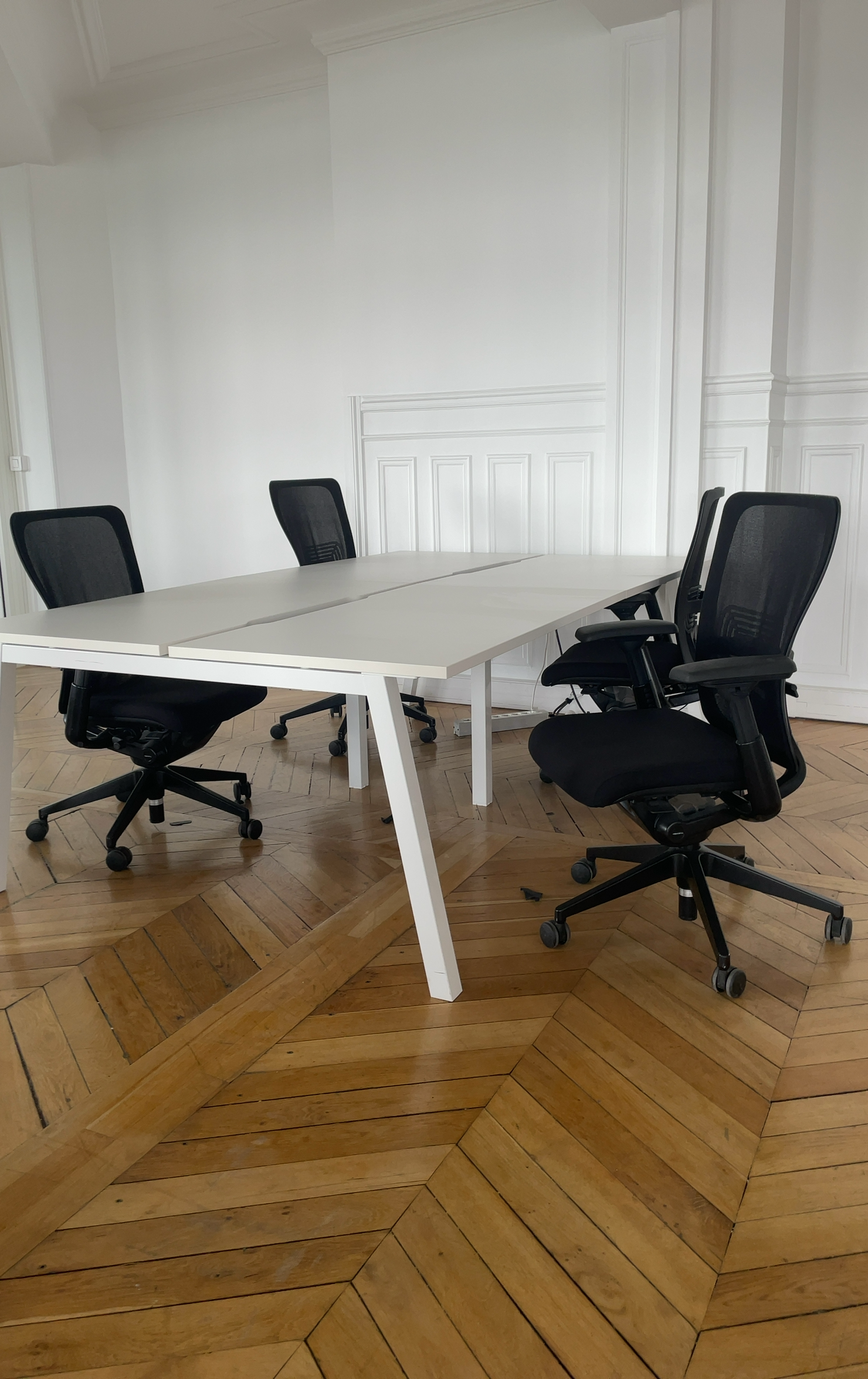 Agencement open space durable avec bureaux blancs et sièges reconditionnés.